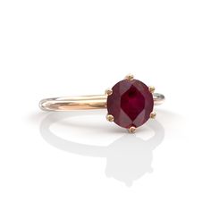 a gold ring with an oval ruby stone