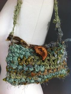 a handbag made out of green and brown material on a mannequin's torso