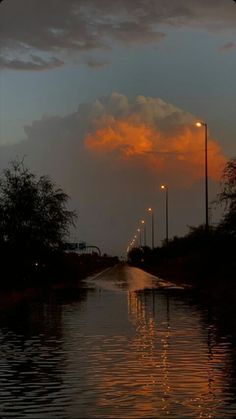 the sun is setting over a flooded street