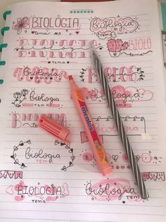 two pens are sitting on top of a notebook with writing and doodles in it