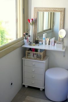 a small white vanity in a bathroom next to a window