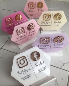 four different types of hair clips in boxes on a tile floor with white and pink tiles