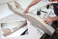 a man is making a model train out of cardboard