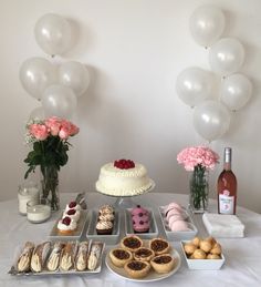 a table topped with lots of desserts and balloons