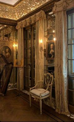 an ornately decorated room with antique furniture and paintings on the walls, along with a staircase