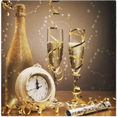 two glasses of champagne next to a clock and confetti