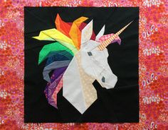 a piece of art that looks like a unicorn's head is featured on a quilt