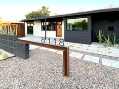 a house with a number sign in front of it and cacti on the side