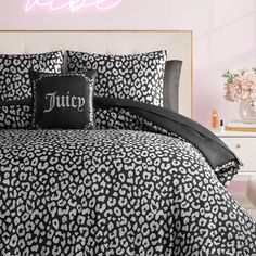 a bed with black and white leopard print comforter, pillows and pillowcases