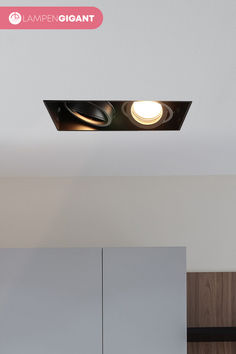 an overhead light in a kitchen area with cabinets and cupboards behind the countertop