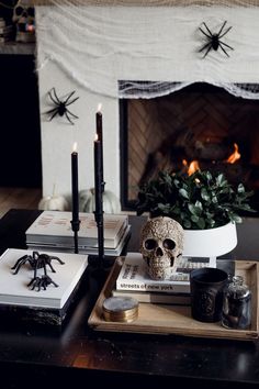 a table topped with books and candles next to a fire place covered in spider webs