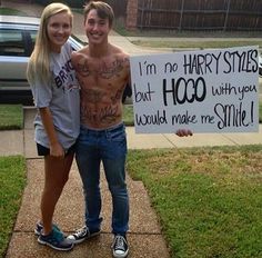 a man and woman standing next to each other in front of a sign that says i'm no harry styles but hog with you would make me smile