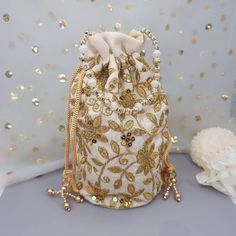 This Potli Bag goes well with both Indian and Western outfits and is superb for Wedding and Festive parties wherein it will best complement your Designer Saree, Lehnga or any other dress. Being lightweight, these bags can easily be wrapped around the wrist using their drawstrings. You can easily keep your personal belongings like Money, Mobile, Cosmetics easily in that. It can be one of the best gifts for any woman. They will just love it. Product Dimensions Length: 23cm Witdh: 12cm Product Care: Gentle Hand Wash/Closure Type: Drawstring/Outer Material: Silk, Inner Material: Other We try to take pictures as normal as we can but colors may slightly vary due to different lighting setups. Please note: No Returns No Exchange. But If you have any issue with your order, Kindly contact us before Festive Embellished Potli Bag As Gift, Festive Gold Embroidery Potli Bag, Bollywood Style Embellished Bags For Wedding, Bollywood Style Embellished Wedding Bag, Elegant Gold Embroidered Fabric For Diwali, Embellished Gold Potli Bag For Wedding, Festive Embroidered Potli Bag For Party, Festive Bollywood Gold Bag, Festive Gold Bollywood Bag