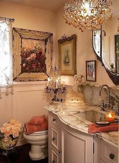 a bathroom with a sink, toilet and chandelier