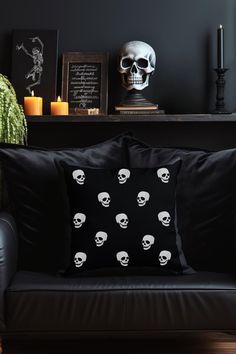 a black couch with skulls on it in front of a shelf filled with candles and pictures