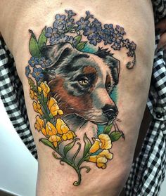 a woman's thigh with a dog and flowers on it