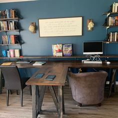 a desk with two chairs in front of it and bookshelves on the wall