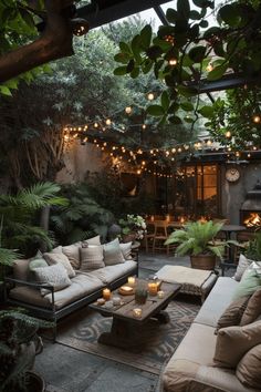 an outdoor living area with couches, tables and lights