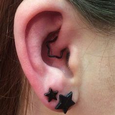 a woman's ear with two black stars on it