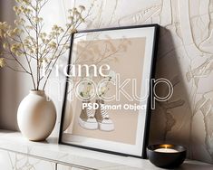 a white vase with flowers in it sitting next to a framed photograph on a mantle