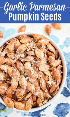 garlic parmesan pumpkin seeds in a white bowl on a blue and white towel