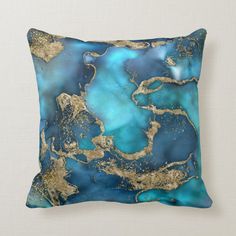 a blue and gold throw pillow sitting on top of a couch