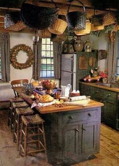 an old fashioned kitchen with lots of counter space and hanging baskets on the ceiling over the island