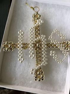 a cross made out of pearls in a box