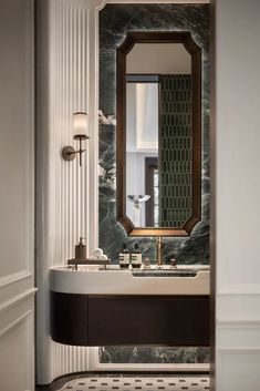 a bathroom sink with a mirror above it and a marble counter top in front of it