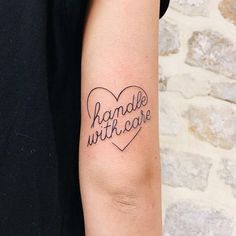 a woman with a tattoo on her arm that says handle with care