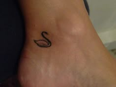 a small black swan tattoo on the ankle