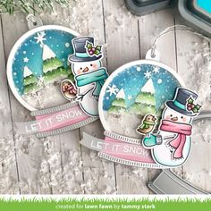 two snow globes are sitting next to each other on a wooden surface with the words let it snow