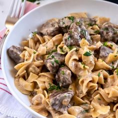 a white bowl filled with pasta and meatballs