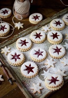 cookies with red and white stars are on a baking tray next to a string of lights