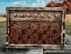 an old wooden sign with letters and numbers written in metal studs on the front