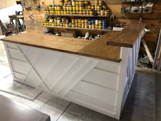 a kitchen counter made out of wood and painted white with yellow cans on the top