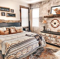 a bed room with a neatly made bed next to a night stand and two windows