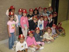 a group of children in fire hats posing for a photo