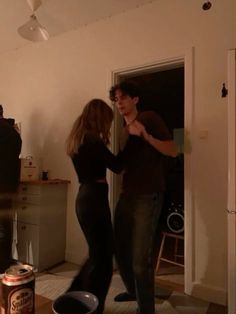 a man and woman dancing in the living room