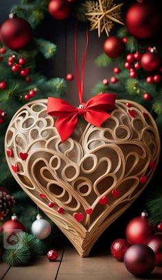 a heart shaped box sitting on top of a wooden floor next to christmas ornaments and decorations