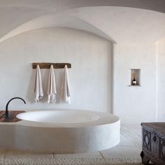 a large white bath tub sitting next to a wooden cabinet