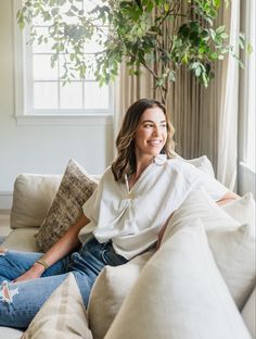 a woman sitting on a couch smiling for the camera