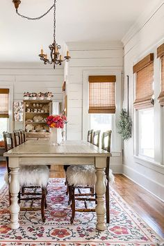 a dining room table with two chairs and a rug on the floor in front of it