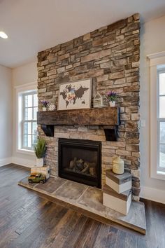 a living room with a stone fireplace and wood floors