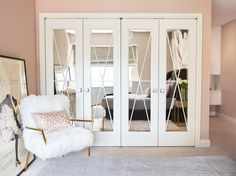 a living room with white furniture and pink walls