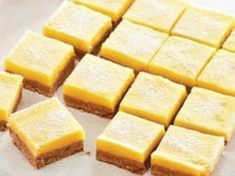 several squares of yellow cake sitting on top of a wooden cutting board