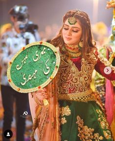 a woman dressed in green and gold holding a sign