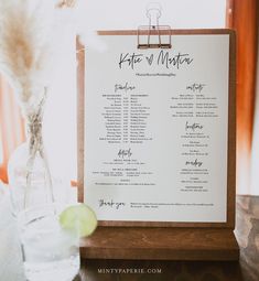 a menu on a clipboard next to a glass vase