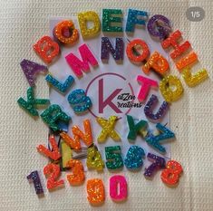 the letters are made out of plastic and have different colored sequins on them