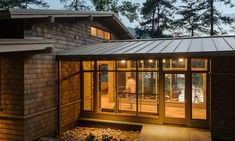 a house that is lit up at night with lights on the outside and inside windows